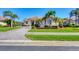 Charming single-story home featuring a red tile roof, well-manicured lawn, and a circular paver driveway at 4326 Corso Venetia Blvd, Venice, FL 34293