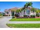 Charming single-story home featuring a red tile roof, well-manicured lawn, and a circular paver driveway at 4326 Corso Venetia Blvd, Venice, FL 34293