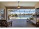 Spacious screened-in lanai with a pool and hot tub overlooking a serene lake at 4326 Corso Venetia Blvd, Venice, FL 34293