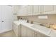 Well-organized laundry room with white cabinets, countertops, sink, and modern washer and dryer at 4326 Corso Venetia Blvd, Venice, FL 34293