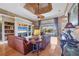 Spacious living room with hardwood floors, built-in shelves, and a view of the pool and lake at 4326 Corso Venetia Blvd, Venice, FL 34293