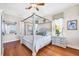 Elegant bedroom with a canopy bed, hardwood floors, and views of the surrounding neighborhood at 4326 Corso Venetia Blvd, Venice, FL 34293