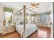 Serene bedroom featuring a four-poster bed, hardwood floors, and ample natural light at 4326 Corso Venetia Blvd, Venice, FL 34293