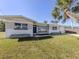 Inviting home exterior showcasing a lush green lawn, complemented by a swaying palm tree for a relaxed, tropical feel at 444 Driftwood Rd, Venice, FL 34293