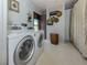 Bright laundry room with large washer and dryer appliances at 444 Driftwood Rd, Venice, FL 34293
