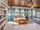 Sunroom-style living area features wood-look ceiling and built-in bookshelves at 444 Driftwood Rd, Venice, FL 34293