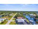 Aerial view of homes lining a canal, featuring boat docks and waterfront access in a sunny neighborhood at 5265 Neville Ter, Port Charlotte, FL 33981
