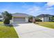Inviting single-story home featuring a well-maintained lawn, a screened garage, and lovely landscaping at 5265 Neville Ter, Port Charlotte, FL 33981