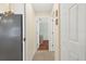 Hallway shows tile flooring, an entrance to a room with hardwood, and closet doors at 5265 Neville Ter, Port Charlotte, FL 33981