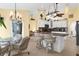 Bright kitchen with a granite-topped island, white cabinets, stainless appliances, and adjacent breakfast nook with wicker chairs at 5265 Neville Ter, Port Charlotte, FL 33981