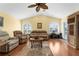 Relaxing living room boasts vaulted ceiling, hardwood floors, arched windows with plantation shutters, and comfortable seating arrangement at 5265 Neville Ter, Port Charlotte, FL 33981