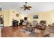 Cozy living room features hardwood floors, vaulted ceilings, comfortable furnishings, and a traditional piano at 5265 Neville Ter, Port Charlotte, FL 33981