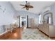 Bright main bedroom featuring ensuite bath access, wood floors, fan and lanai access at 5265 Neville Ter, Port Charlotte, FL 33981