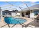 A beautiful caged swimming pool surrounded by stone pavers with a view of the backyard at 5265 Neville Ter, Port Charlotte, FL 33981