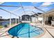 A beautiful caged swimming pool surrounded by stone pavers with a view of the canal at 5265 Neville Ter, Port Charlotte, FL 33981