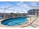 A beautiful caged swimming pool surrounded by stone pavers with a view of the canal at 5265 Neville Ter, Port Charlotte, FL 33981