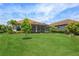Well-maintained backyard with ample green space, palm trees, and screened-in lanai for outdoor living at 5585 Semolino St, Nokomis, FL 34275