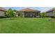 Spacious backyard features lush green grass and a screened lanai, ideal for entertaining or relaxing at 5585 Semolino St, Nokomis, FL 34275