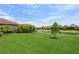 Lush backyard with healthy green grass, beautiful landscaping, and tranquil water view at 5585 Semolino St, Nokomis, FL 34275