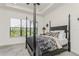 Elegant bedroom features a black four-poster bed and large windows at 5585 Semolino St, Nokomis, FL 34275