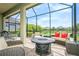 Screened outdoor patio features a fire pit, ample seating, and a serene lake view at 5585 Semolino St, Nokomis, FL 34275