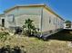 Exterior view of home with siding, well-maintained lawn, landscaping, and a glimpse of a vehicle at 5619 Bayshore Rd # 421, Palmetto, FL 34221