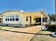 Charming manufactured home with bright yellow siding, covered carport, and well-maintained landscaping at 5619 Bayshore Rd # 421, Palmetto, FL 34221