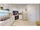 Well-lit kitchen with white cabinets, modern appliances, and tile flooring at 5619 Bayshore Rd # 421, Palmetto, FL 34221