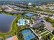 Aerial view featuring a stunning pool, clubhouse, tennis courts, and surrounding scenic lakes at 5632 Long Shore Loop, Sarasota, FL 34238