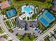 Aerial view of an amenity center featuring two tennis courts, a large pool, and beautiful landscaping at 5632 Long Shore Loop, Sarasota, FL 34238