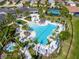 Aerial view featuring a luxurious community pool area with palm trees, lounge chairs, and well-manicured landscaping at 5632 Long Shore Loop, Sarasota, FL 34238