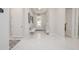 Bright foyer featuring a bench, chandelier and white marble floors at 5632 Long Shore Loop, Sarasota, FL 34238