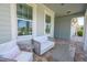 Covered front porch with a comfortable seating area and views of the neighborhood at 5632 Long Shore Loop, Sarasota, FL 34238