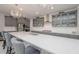 Modern kitchen features gray cabinets, stone backsplash, large island with seating, and stainless appliances at 5632 Long Shore Loop, Sarasota, FL 34238