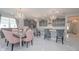 Bright kitchen features stylish gray cabinets, marble floors, a large island with seating, and elegant chandeliers at 5632 Long Shore Loop, Sarasota, FL 34238