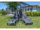 Outdoor lounge chairs for relaxation on a sunny day in the lawn near the screened patio at 5632 Long Shore Loop, Sarasota, FL 34238
