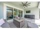 Cozy screened patio with a ceiling fan, TV, seating area, and access to the pool area at 5632 Long Shore Loop, Sarasota, FL 34238
