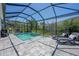 Stunning screened-in pool with a spa, lounge chairs, and lush landscaping at 5632 Long Shore Loop, Sarasota, FL 34238