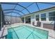 Sparkling screened-in pool with outdoor cooking area and lounge chairs for ultimate relaxation at 5632 Long Shore Loop, Sarasota, FL 34238