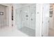 Modern bathroom featuring a walk-in shower with dual shower heads and marble floors at 5632 Long Shore Loop, Sarasota, FL 34238
