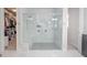 Stylish walk-in shower with marble tile, dual shower heads, and glass doors at 5632 Long Shore Loop, Sarasota, FL 34238