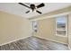 Bright bedroom featuring wood-look floors, ceiling fan, and multiple windows at 5755 Oxalis Rd, Venice, FL 34293