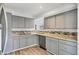 Well-appointed kitchen featuring gray cabinets, stainless steel sink, stone countertops, and ample counter space at 5755 Oxalis Rd, Venice, FL 34293