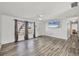 Open-concept living room featuring hardwood floors, a ceiling fan, and a mounted flat-screen television at 5755 Oxalis Rd, Venice, FL 34293