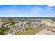 Expansive aerial showcases residences with scenic waterways and green spaces under a sunny sky at 5800 Sabal Trace Dr # 101, North Port, FL 34287