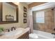 Cozy bathroom showcasing a tiled tub and shower, a framed mirror, and a vanity with storage at 5800 Sabal Trace Dr # 101, North Port, FL 34287
