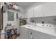 Well-equipped laundry room with washer, dryer, shelving, and ample storage space for cleaning supplies at 5800 Sabal Trace Dr # 101, North Port, FL 34287