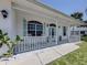Inviting front porch with white railings, comfortable seating, and views of the surrounding neighborhood at 5931 Plover Rd, Venice, FL 34293