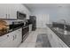 Modern kitchen with stainless steel appliances, black granite countertops, and white cabinets at 5931 Plover Rd, Venice, FL 34293