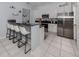 Bright kitchen featuring white cabinets, modern appliances, and a breakfast bar with seating at 5931 Plover Rd, Venice, FL 34293